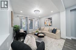 Living area featuring recessed lighting, a crystal chandelier, multiple windows with blinds, and wood-finish flooring - 