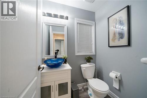 White vanity with a blue vessel sink, framed mirror, and modern light fixture - 151 Baldwin Drive, Cambridge, ON - Indoor Photo Showing Bathroom