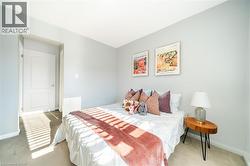 Carpeted bedroom with light gray wall finishes and white trim - 