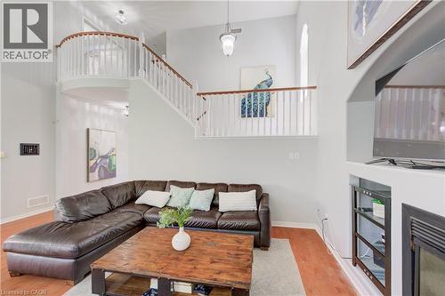 Two-story living area featuring wood-finish flooring and a built-in media niche with an electric fireplace - 23 Buerkle Court, Kitchener, ON - Indoor Photo Showing Living Room With Fireplace