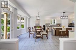 Open-concept living space featuring light gray tile flooring and a bay window - 