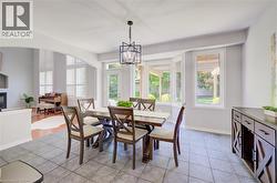 Dining area featuring tile flooring, a geometric chandelier, and an abundance of natural light from multiple windows - 