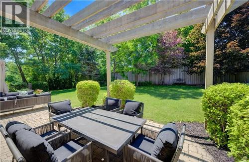 Spacious paver patio featuring a wooden pergola and manicured landscaping - 23 Buerkle Court, Kitchener, ON - Outdoor