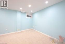 Carpeted empty room with baseboards and recessed lighting - 