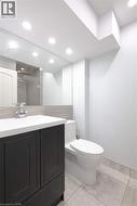 Bathroom featuring vanity, a stall shower, light tile patterned flooring, and recessed lighting - 
