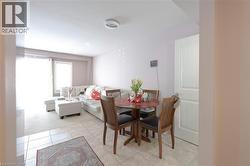 Dining space featuring a textured ceiling, light tile patterned flooring, and light carpet - 