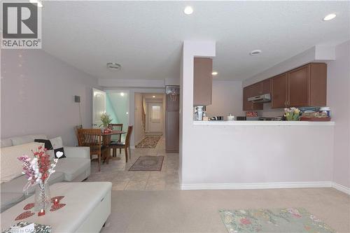 Living room featuring light colored carpet, recessed lighting, light tile patterned floors, and a textured ceiling - 535 Margaret Street Unit# 74, Cambridge, ON 