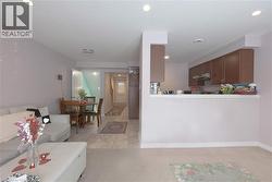 Living room featuring light colored carpet, recessed lighting, light tile patterned floors, and a textured ceiling - 