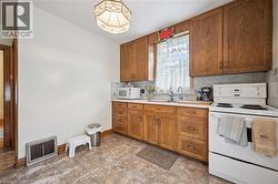 Kitchen featuring wood-finish cabinetry, light-toned countertops, and a tile backsplash - 