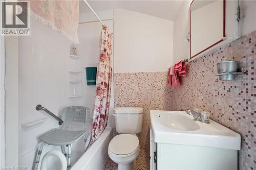 Bathroom featuring a white bathtub, white toilet, and a white corner vanity with a single basin sink - 75 Arnold Street, Kitchener, ON - Indoor Photo Showing Bathroom
