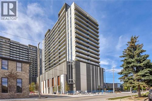 Contemporary high-rise building featuring multiple levels of private balconies, a modern facade with contrasting paneling, and a distinct architectural base - 50 S Grand Avenue S Unit# 1002, Cambridge, ON - Outdoor With Facade