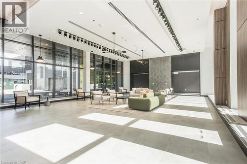 Spacious common area featuring full-height window walls, light-toned large format tile flooring, and track lighting - 50 S Grand Avenue S Unit# 1002, Cambridge, ON - Indoor Photo Showing Other Room