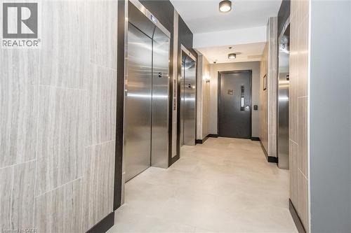 Hallway featuring light-toned large format floor tiles and vertical wall paneling - 50 S Grand Avenue S Unit# 1002, Cambridge, ON - Indoor Photo Showing Other Room