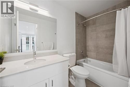 Contemporary bathroom featuring a white vanity with an integrated sink, a large wall-mounted mirror, and a chrome faucet - 50 S Grand Avenue S Unit# 1002, Cambridge, ON - Indoor Photo Showing Bathroom