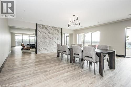 Open concept living space featuring wood-finish flooring and a decorative stone accent wall - 50 S Grand Avenue S Unit# 1002, Cambridge, ON - Indoor Photo Showing Dining Room