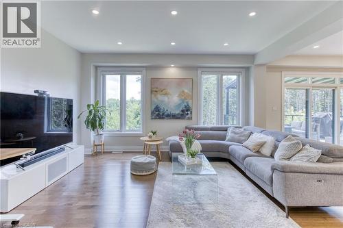 Open-concept living space featuring wood-finish flooring, recessed lighting, and multiple large windows - 71 Ian Ormston Drive, Waterloo, ON 