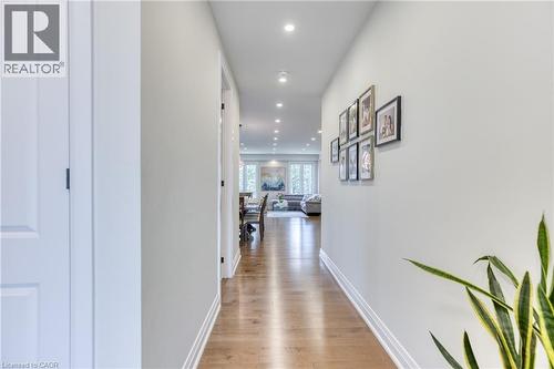 Hallway featuring recessed lighting, light wood-finish flooring, white baseboards, and neutral wall paint - 71 Ian Ormston Drive, Waterloo, ON 