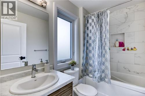 Bathroom featuring a combination bathtub and shower with large format tile surround and recessed shelving - 71 Ian Ormston Drive, Waterloo, ON 