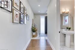 Hallway featuring wood-finish flooring, recessed lighting, and white baseboards - 