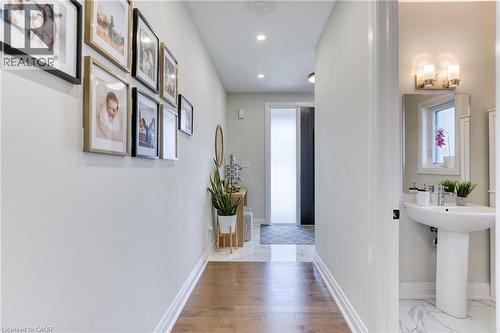 Hallway featuring wood-finish flooring, recessed lighting, and white baseboards - 71 Ian Ormston Drive, Waterloo, ON 