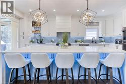 Central kitchen island featuring a light-colored countertop and a blue base with under-cabinet lighting - 