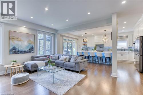 Open-concept living space featuring wood-finish flooring, recessed lighting, and large windows - 71 Ian Ormston Drive, Kitchener, ON - Indoor Photo Showing Living Room