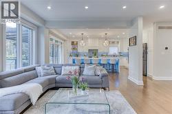 Open-concept living area featuring rich wood-finish flooring, recessed lighting, and expansive windows - 