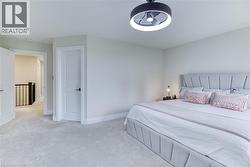 Bright bedroom space featuring light-toned carpeting and walls - 