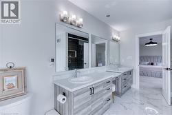 Double vanity with light wood-finish cabinetry and white countertops - 