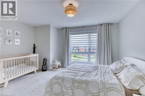 Bedroom with light gray wall paint, light-colored carpet flooring, and a large window featuring blinds and drapes - 71 Ian Ormston Drive, Kitchener, ON - Indoor Photo Showing Bedroom