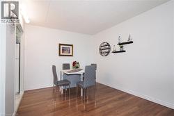 Spacious room featuring wood-finish flooring, white walls, and a textured ceiling - 