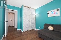 Room featuring wood-finish flooring and vibrant teal walls - 