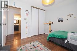 Room featuring wood-finish flooring, white walls, and a ceiling-mounted light fixture - 