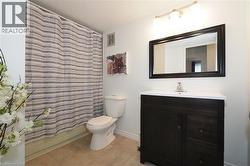 Bathroom featuring a dark wood-finish vanity with a white countertop and basin sink - 
