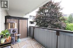 Balcony featuring a privacy storage unit, white brick exterior wall, and metal railing - 