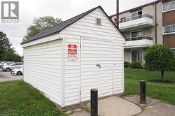 White siding shed with a gabled asphalt shingle roof - 