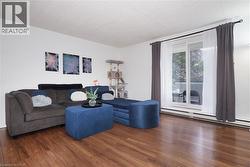 Living area featuring wood-finish flooring, white walls, and a sliding glass door with a transom window - 