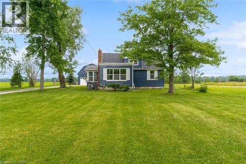 Expansive green lawn with mature trees framing the exterior - 87 Mud Street E, Grimsby, ON 