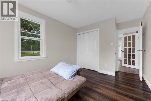 Bedroom featuring wood-finish flooring, a double-pane window, and a bi-fold closet - 87 Mud Street E, Grimsby, ON 