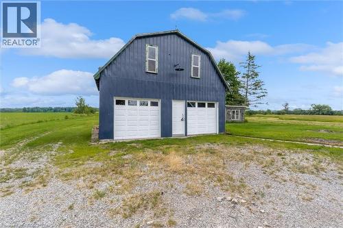 Two-story barn structure featuring a gambrel roof and vertical board siding - 87 Mud Street E, Grimsby, ON 