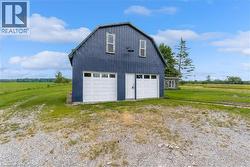 Two-story barn structure featuring a gambrel roof and vertical board siding - 