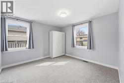 Unfurnished bedroom with light colored carpet and baseboards - 