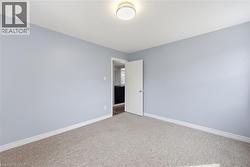 Unfurnished room featuring baseboards and light carpet - 
