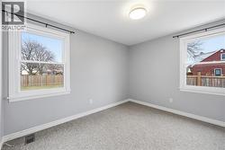 Empty room featuring light carpet and baseboards - 