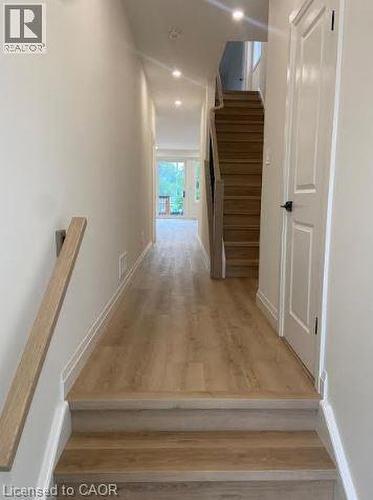 Entryway featuring wood-finish flooring extending into the hallway and up the staircase - 48 Melbourne Street, Hamilton, ON - Indoor Photo Showing Other Room
