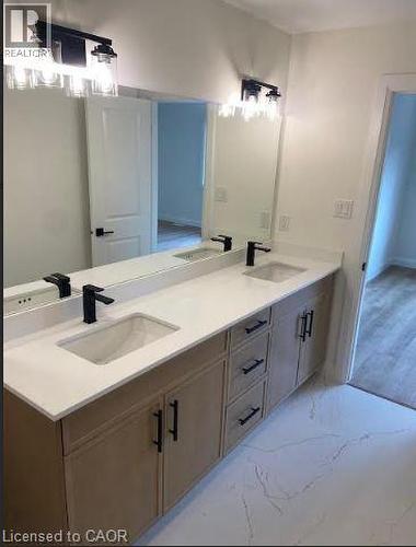 Dual vanity with white countertops, integrated rectangular sinks, and matte black fixtures - 48 Melbourne Street, Hamilton, ON - Indoor Photo Showing Bathroom