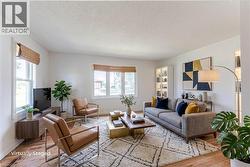 Bright living space featuring original hardwood floors and ample natural light from multiple windows - 