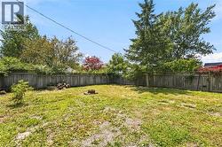 Expansive backyard featuring a wood privacy fence and mature trees - 