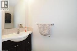 Bathroom vanity with a white integrated sink, chrome faucet, and dark wood-finish cabinetry - 