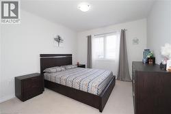Bright sleeping area featuring neutral carpeting and white wall finishes - 